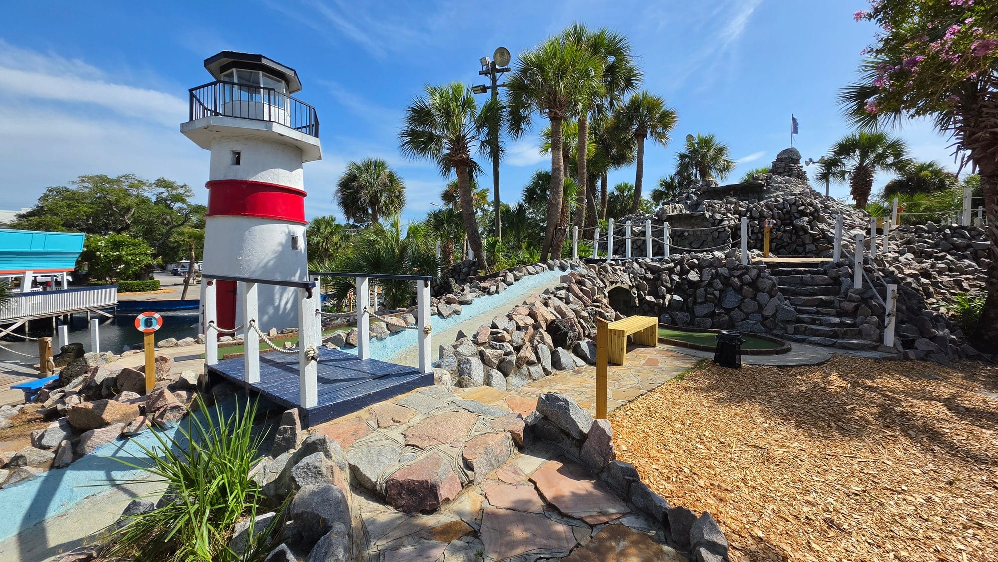 Red-and-white lighthouse and rocky course features at Captain Myrtle Mini Golf in Myrtle Beach